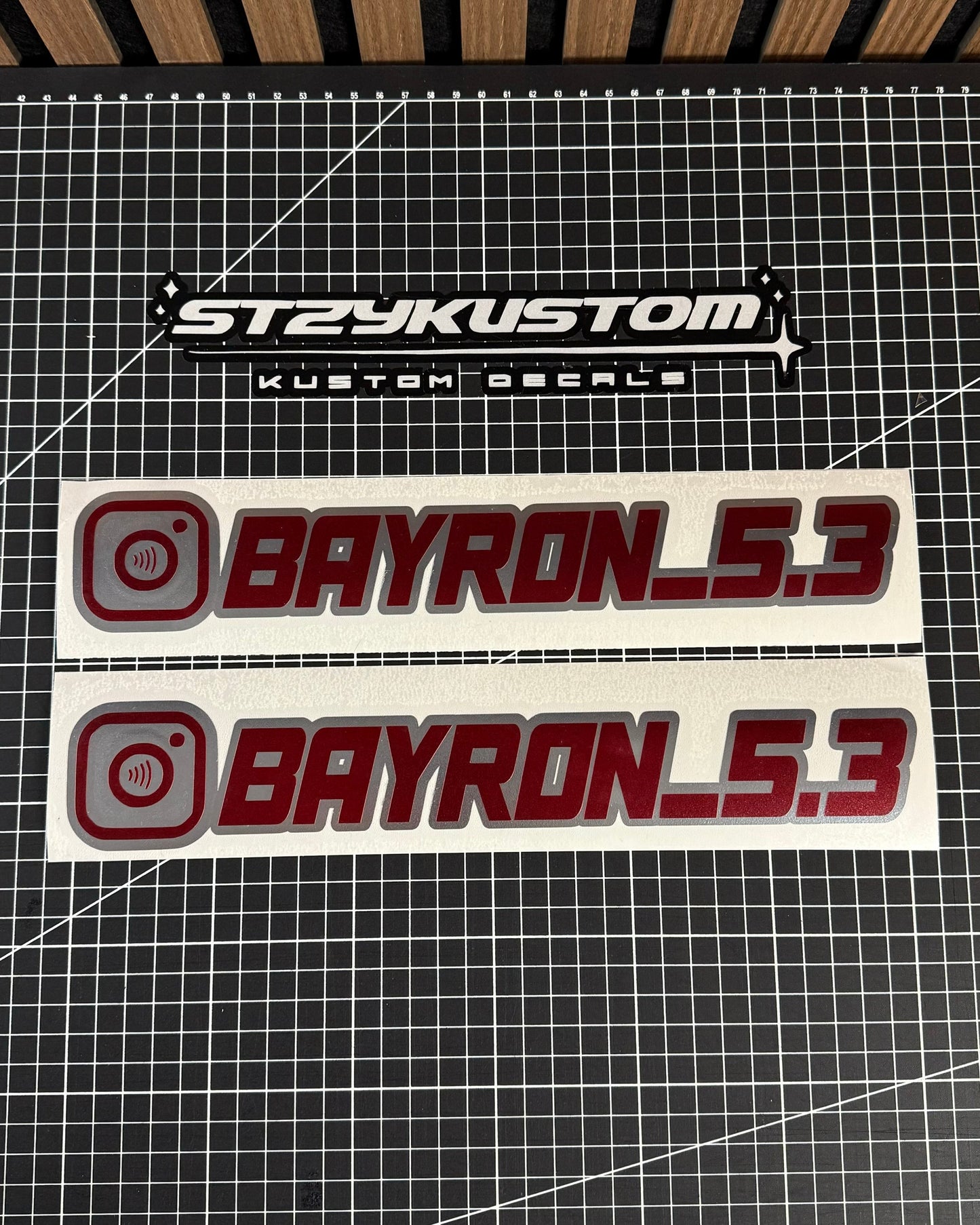Two 'BAYRON_5.3' decals with 'STEKUSTOM' branding on a grid background.