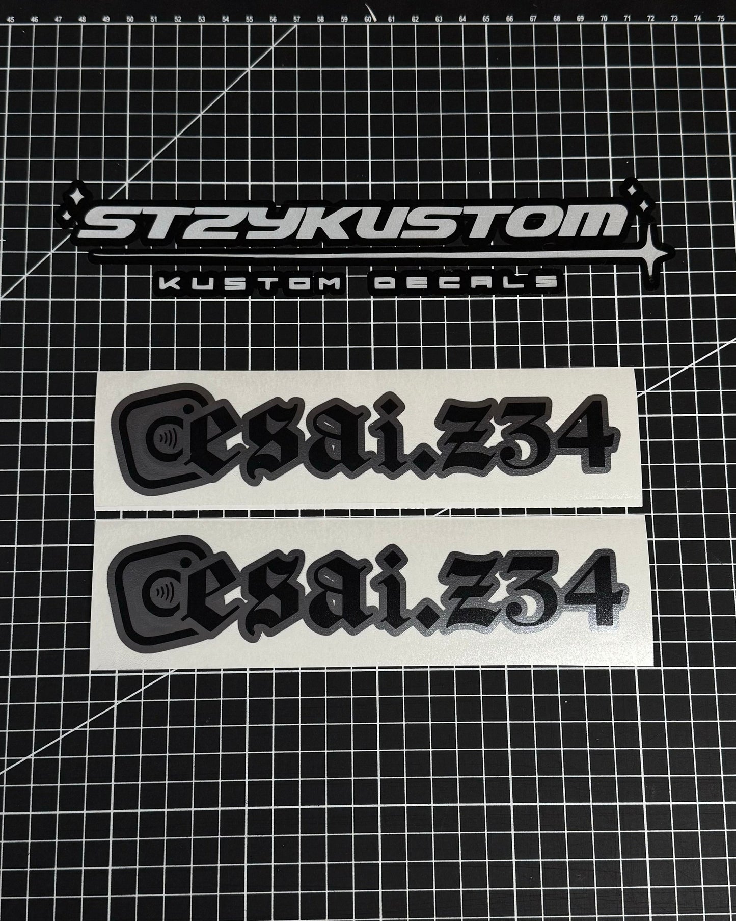 Two 'esai.234' decals on a grid background with 'STZYKUSTOM' branding.