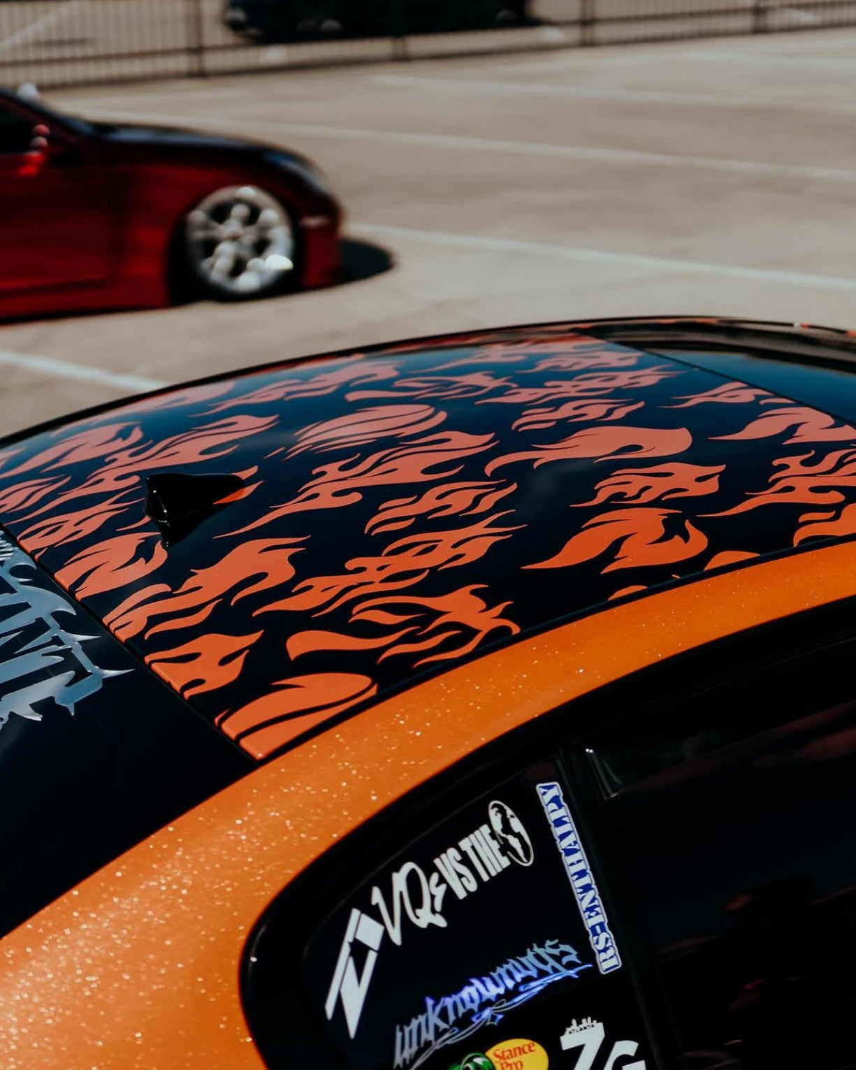 Close-up of a car with a colorful design and visible branding in an outdoor setting.