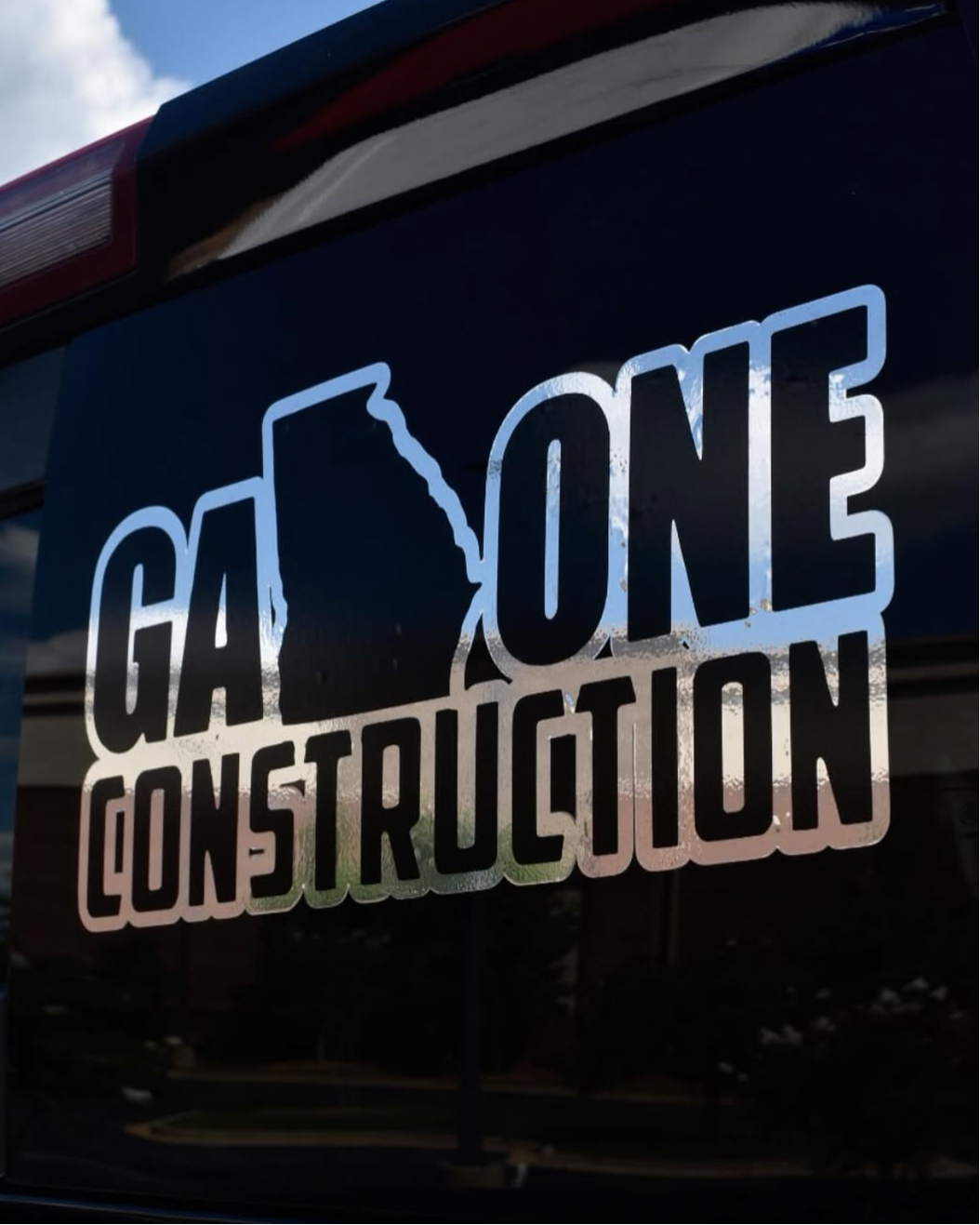 Car with 'G4 One Construction' logo on a dark background