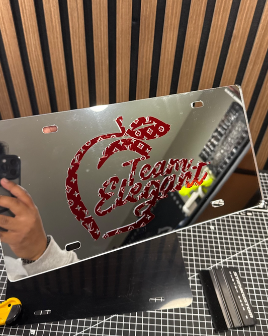 Metallic plate with red text on a cutting mat